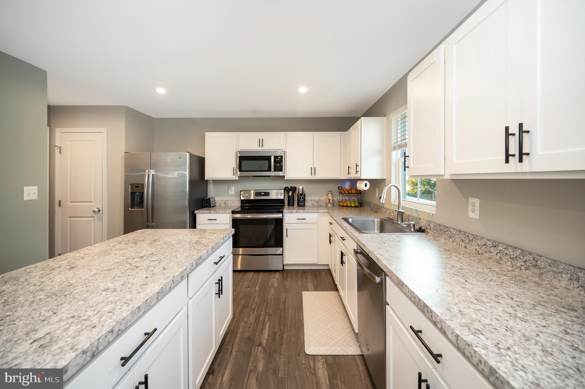 2188 Mallard Lane Locust Grove, VA 22508 - Photo 15 of 45 a large kitchen with kitchen island granite countertop a sink a counter top space appliances and cabinets