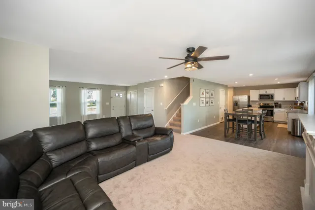 a living room with furniture and a ceiling fan