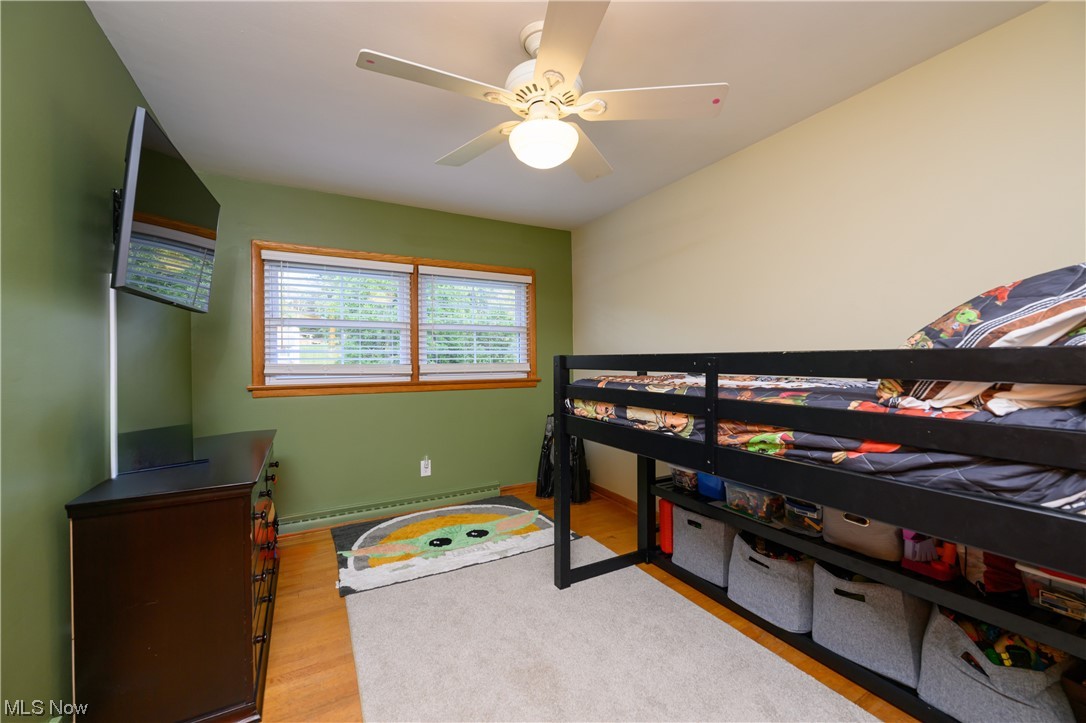 2383 Sunnybrook Road Mogadore, OH 44260 - Photo 21 of 31 Hardwood floored bedroom featuring a baseboard radiator and ceiling fan
