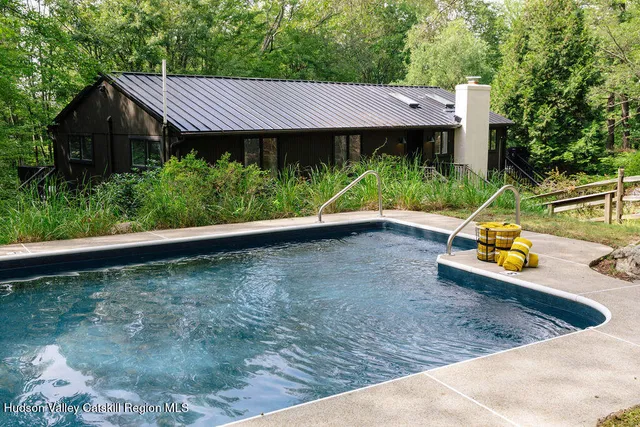 a view of a small house with wooden fence