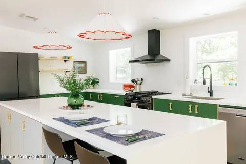 a kitchen with stainless steel appliances a white table and chairs in it