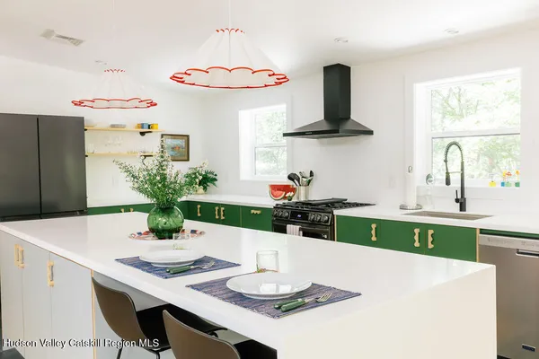 a kitchen with stainless steel appliances a white table and chairs in it