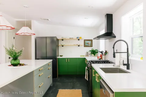 a kitchen with kitchen island stainless steel appliances a sink stove and refrigerator