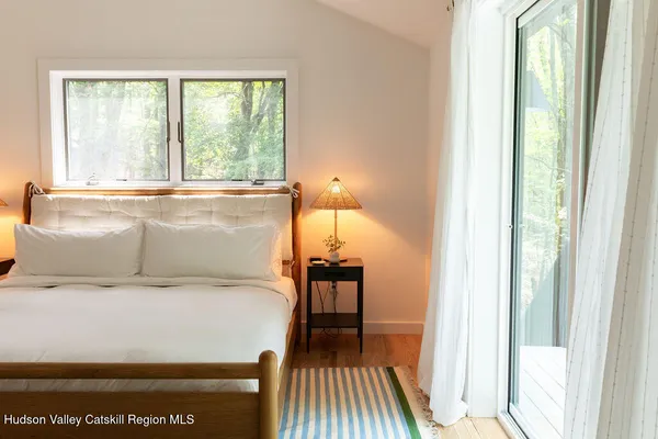 a bedroom with a bed and a large window