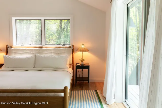 a bedroom with a bed and a large window