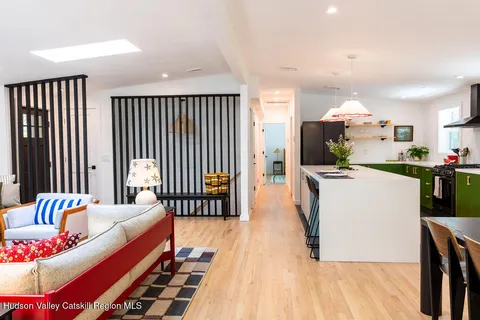 a living room with furniture and a dining table with wooden floor
