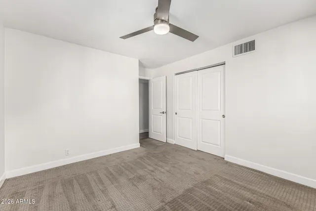 an empty room with a empty space and a ceiling fan