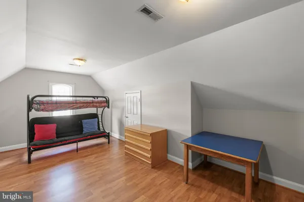 a bedroom with furniture and wooden floor