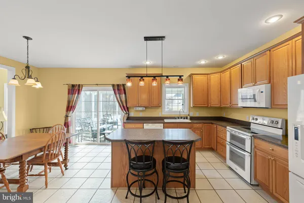 a kitchen with a dining table chairs and white cabinets