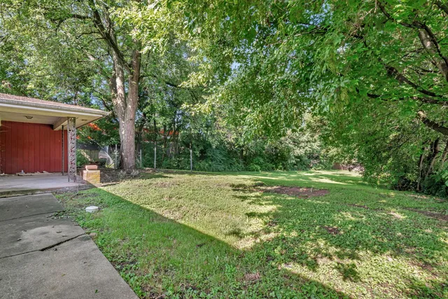 a view of a house with a yard and a bench