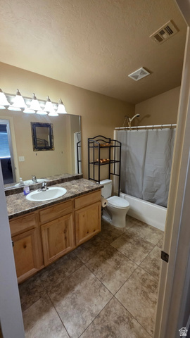 1330 North Dixie Downs Road, Unit 72 St. George, UT 84770 - Photo 17 of 21 Full bathroom with vanity, shower / tub combo with curtain, a textured ceiling, and light tile patterned floors