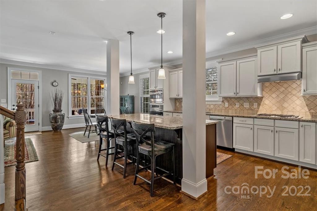 771 Harvest Pointe Drive Fort Mill, SC 29708 - Photo 20 of 48 a kitchen with stainless steel appliances granite countertop a stove top oven a sink with island and chairs