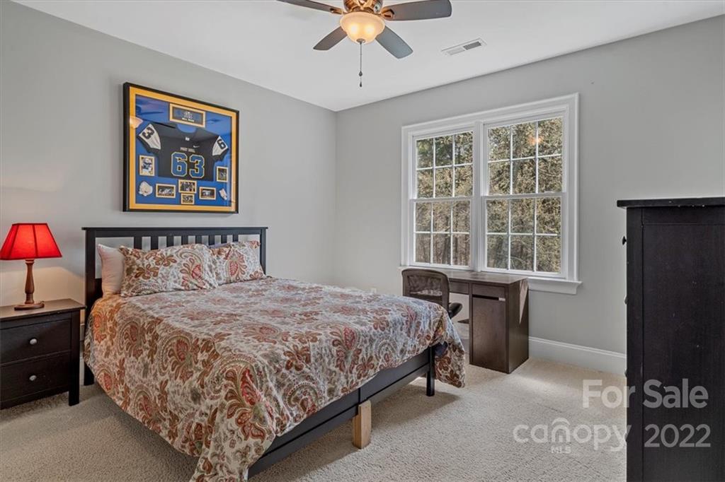 771 Harvest Pointe Drive Fort Mill, SC 29708 - Photo 27 of 48 a bedroom with a bed and a chandelier