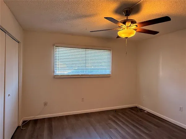 a view of a room with wooden floor and fan