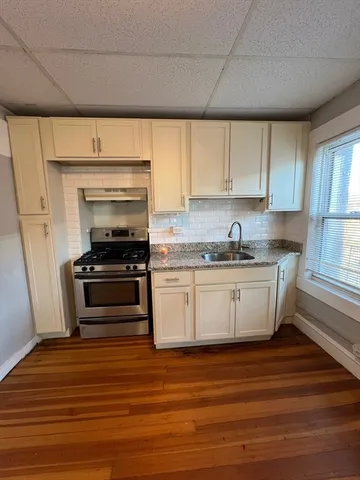 a kitchen with granite countertop a stove and cabinets