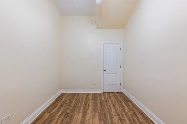 a view of a small space with wooden floor and a window