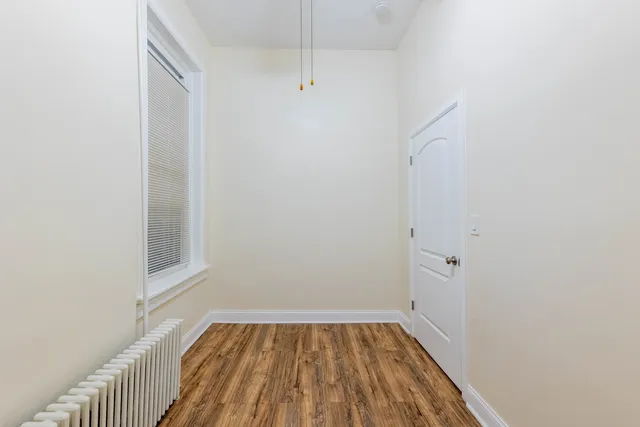a view of a room with wooden floor and small window