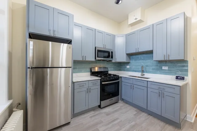 a kitchen with cabinets stainless steel appliances and a sink