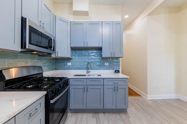 a kitchen with stainless steel appliances a sink a stove a microwave and cabinets
