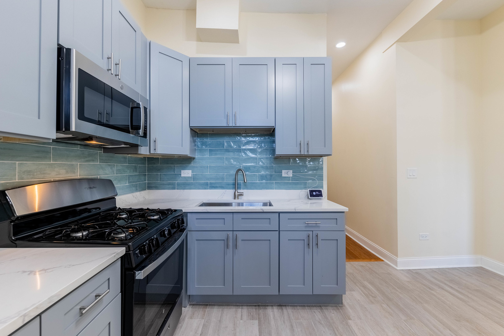 4549 South Wabash Avenue, Unit 1 Chicago, IL 60653 - Photo 29 of 44 a kitchen with stainless steel appliances a sink a stove a microwave and cabinets
