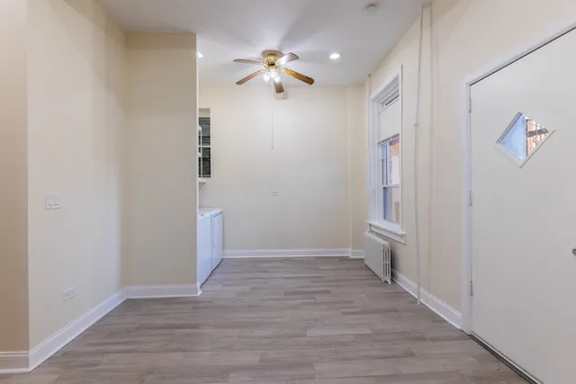 a view of a hallway with wooden floor and a chandelier fan