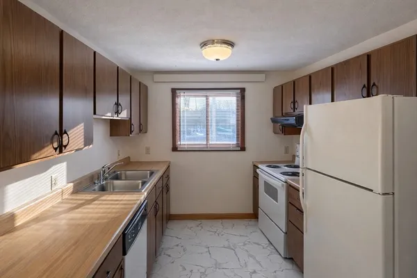 a kitchen with a stove a refrigerator and a sink