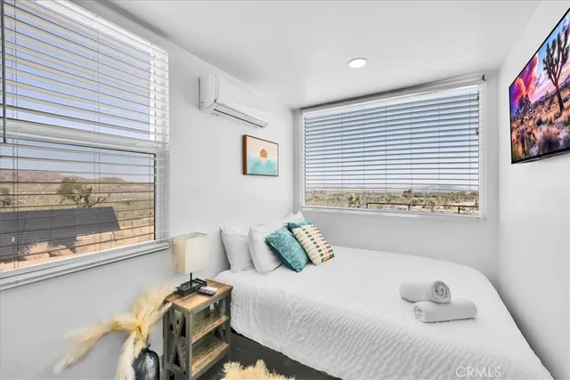 a bedroom with a bed and a potted plant