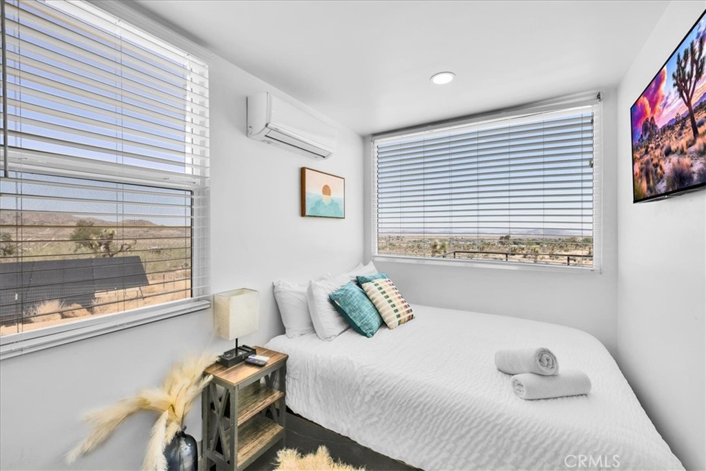 6816 Saddleback Road Joshua Tree, CA 92252 - Photo 21 of 71 a bedroom with a bed and a large window