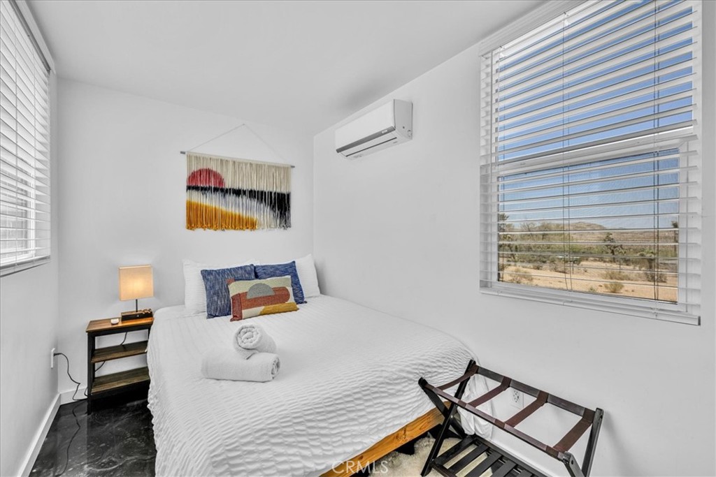 6816 Saddleback Road Joshua Tree, CA 92252 - Photo 24 of 71 a bedroom with a bed and wooden floor