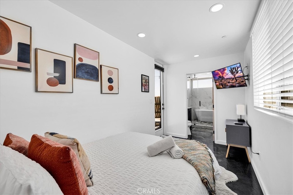 6816 Saddleback Road Joshua Tree, CA 92252 - Photo 28 of 71 a bedroom with a bed and a potted plant