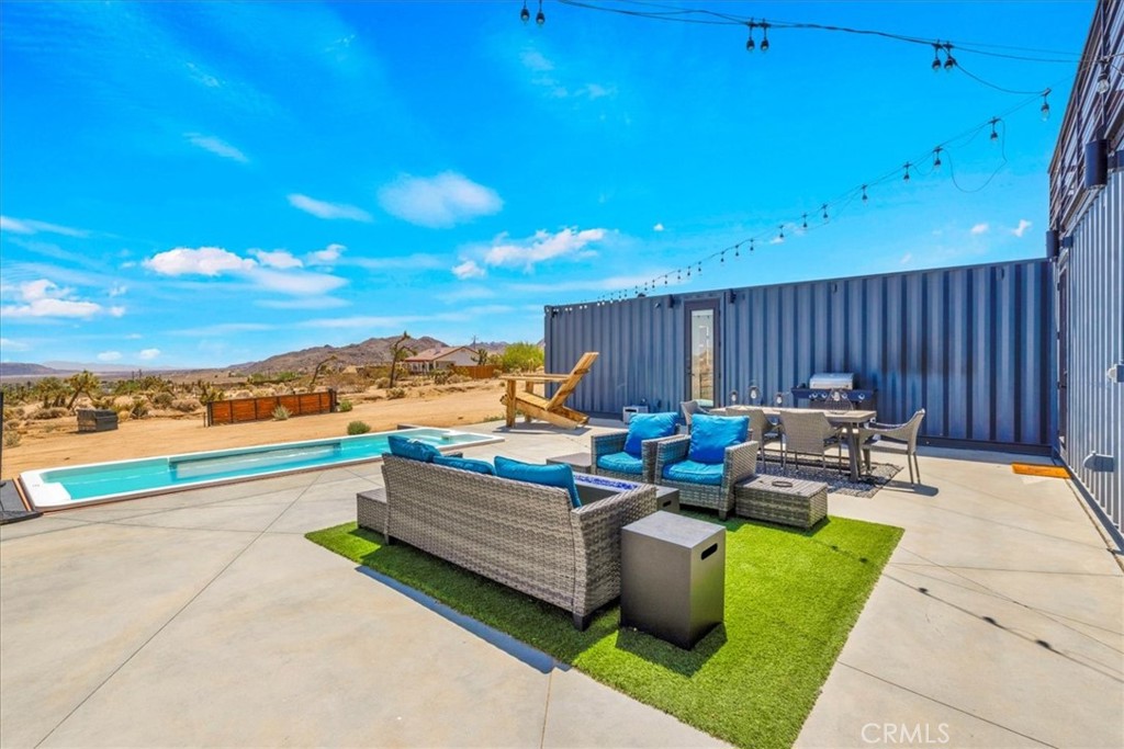 6816 Saddleback Road Joshua Tree, CA 92252 - Photo 33 of 71 a view of a patio with dining table and chairs with wooden floor