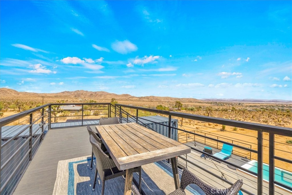 6816 Saddleback Road Joshua Tree, CA 92252 - Photo 41 of 71 a view of a balcony with wooden floor and outdoor seating