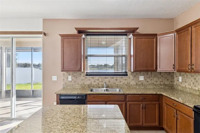 a kitchen with stainless steel appliances granite countertop a sink stove and cabinets
