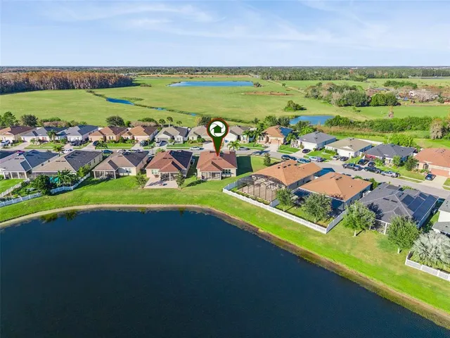 an aerial view of a house with a garden and lake view