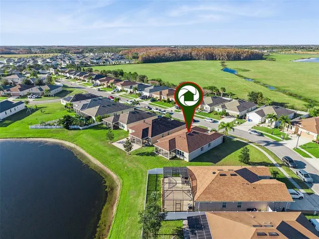 an aerial view of residential houses with outdoor space and ocean view