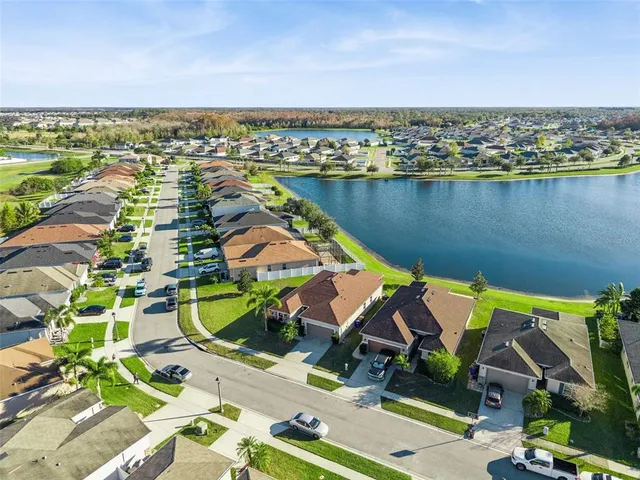 an aerial view of residential houses with outdoor space and ocean view