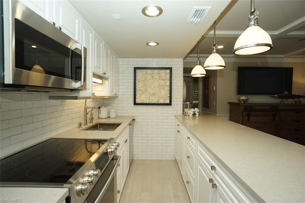 480 5th Street South, Unit 102 Naples, FL 34102 - Photo 9 of 24 a bathroom with a sink a large mirror and a bathtub