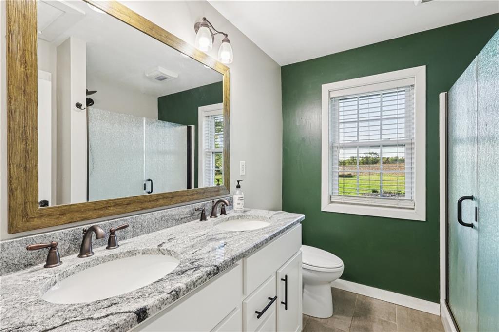 1188 East Lake Road Transfer, PA 16154 - Photo 15 of 32 a bathroom with a granite countertop sink toilet a large mirror and a window
