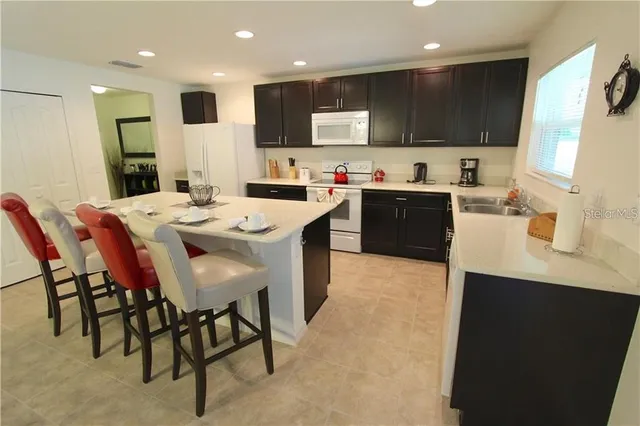 a large kitchen with kitchen island a dining table and chairs