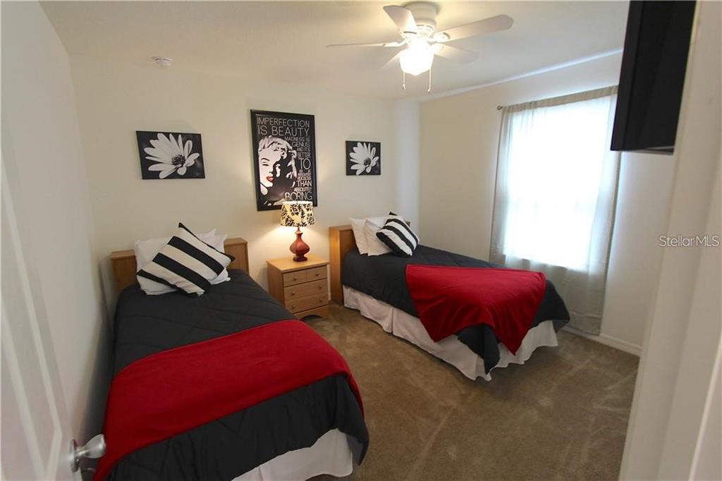 957 Emerald Green Court Kissimmee, FL 34746 - Photo 15 of 29 a bedroom with furniture and a chandelier