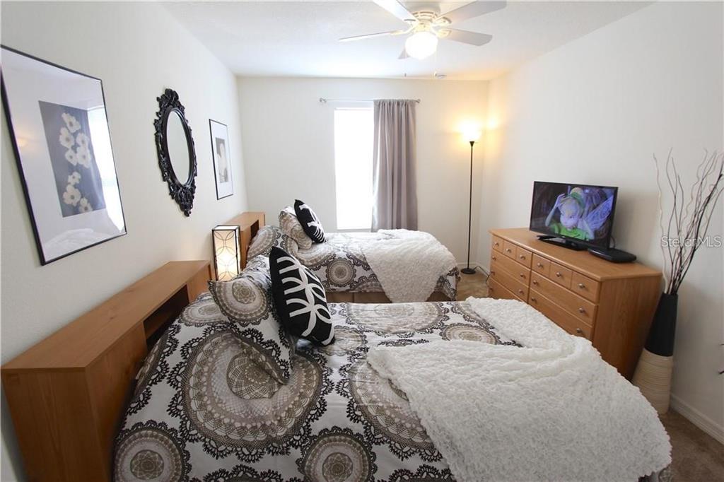 957 Emerald Green Court Kissimmee, FL 34746 - Photo 19 of 29 a bedroom with a bed and furniture