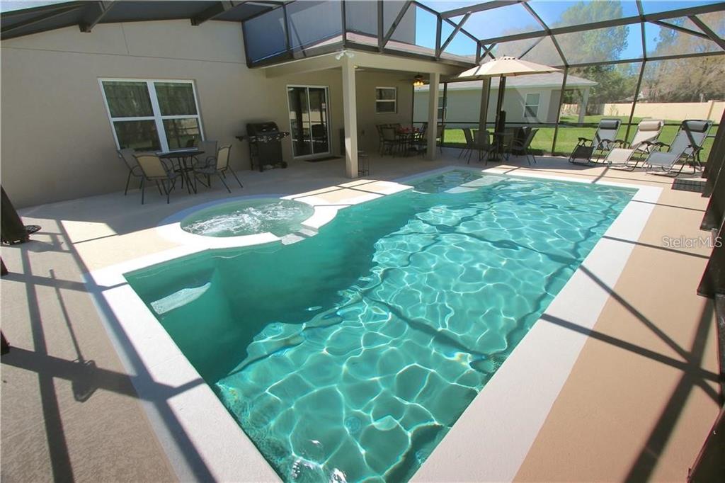 957 Emerald Green Court Kissimmee, FL 34746 - Photo 2 of 29 a view of a patio with table and chairs potted plants with floor to ceiling window