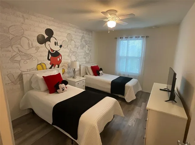 a bedroom with two beds and a chandelier