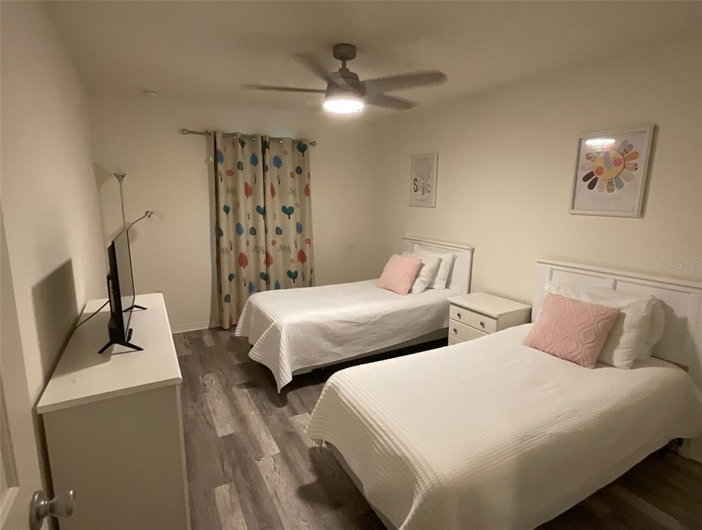 957 Emerald Green Court Kissimmee, FL 34746 - Photo 29 of 29 a bedroom with two beds and a chandelier