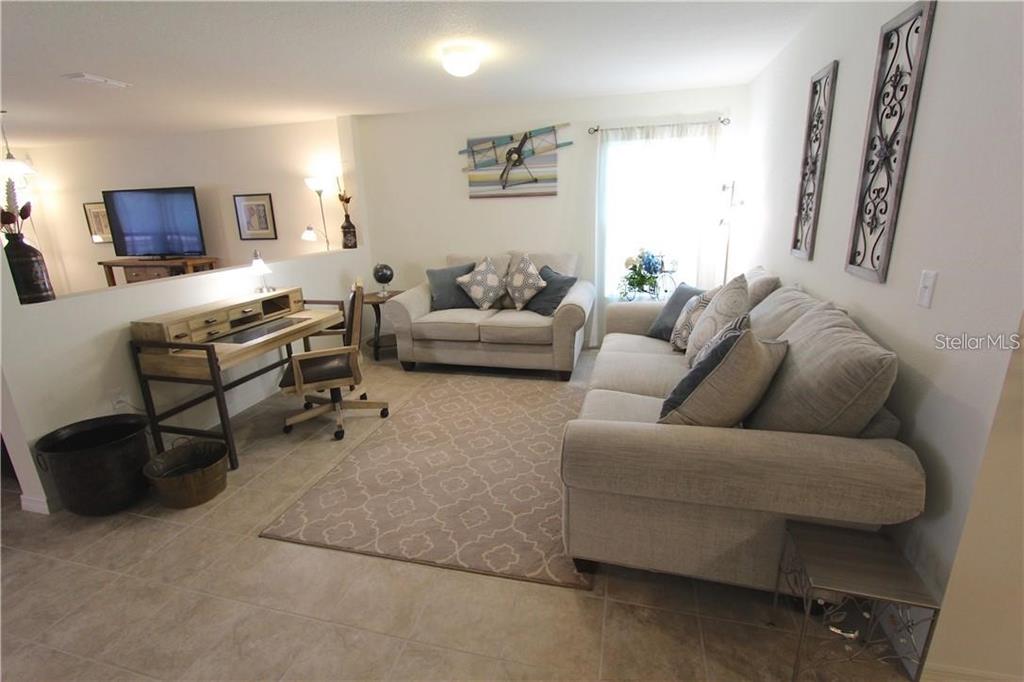 957 Emerald Green Court Kissimmee, FL 34746 - Photo 8 of 29 a living room with furniture and a flat screen tv
