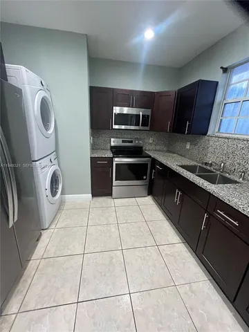 a kitchen with a stove top oven and cabinets