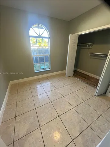 a view of an empty room and a ceiling fan