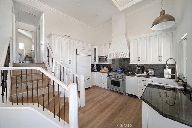a kitchen with granite countertop a sink a counter top space stainless steel appliances and cabinets