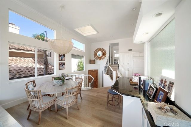 a dining room with wooden floor and large windows