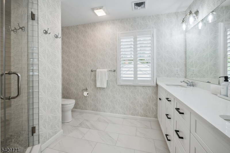 41 Milton Avenue Summit, NJ 07901 - Photo 16 of 39 a bathroom with a double vanity sink a toilet and a shower